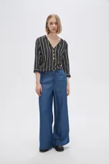 Pantalón de lyocell azul con bolsillos, corte holgado y de calce alto.