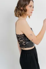 Top crop negro de cuero ecológico con tirantes finos y espalda de encaje floral con base nude.