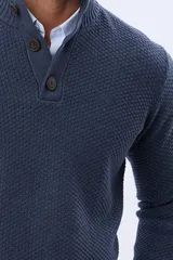 Buzo tejido color beige con textura, cuello alto con botones y manga larga.