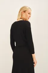 Cardigan crop negro tejido en punto desagujado con lurex, escote V cruzado y ajuste en la cintura.