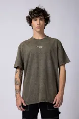 Remera negra con efecto gastado, corte holgado y estampa frontal con la frase 'Astral Energy' en blanco.