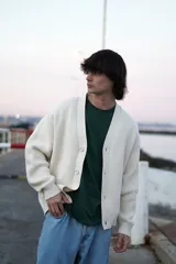 Cardigan de punto color crema con botones. Corte clásico y amplio.