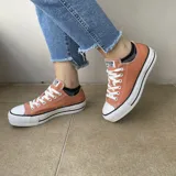 Zapatillas de mujer en color naranja, con suela elevada y cierre de cordones.