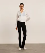 Campera rompevientos deportiva blanca, confeccionada en poliamida, con capucha, cierre delantero en cremallera, tirador gomoso y puños ajustados.
