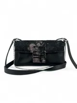 Cartera bandolera negra de cuero con solapa superior con cierre magnético y herraje metálico con forma de S. Incluye correa de cuero ajustable y cadena metálica.