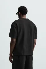 Camiseta de hombre color gris oscuro, de corte amplio, cuello redondo y manga corta.