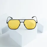 Lentes de sol con marco geométrico negro y lentes amarillos con protección UV400.