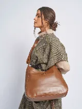 Bandolera marrón de cuero sintético con correa ajustable y logo triangular metálico.