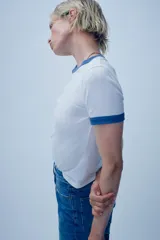 Camiseta blanca de algodón con cuello redondo y mangas cortas con ribete azul marino en cuello y mangas.