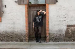 Pantalón negro de tejido calado con aberturas.