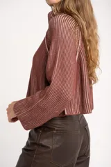 Sweater de punto morado con cierre metálico parcial en el cuello alto y mangas largas.