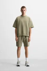 Sudadera negra de corte relaxed fit, confeccionada en tejido interlock de algodón con elasticidad. Tiene cuello redondo, manga corta y bajo acabado en rib.