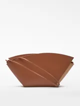 Bolso de hombro de cuero color beige y negro, con forma geométrica asimétrica y asa fina negra.