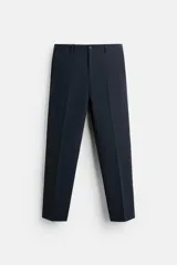 Pantalón de vestir azul marino, de corte slim fit, con bolsillos laterales y traseros de vivo con botón. Se ajusta a la cintura con cierre frontal con cremallera y botón.