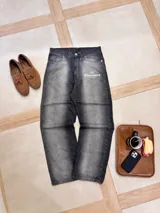 Pantalón de jean gris oscuro con corte amplio y estampado con el logo de la marca en la pierna izquierda.