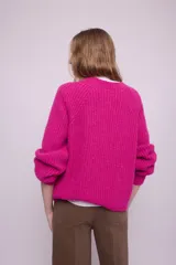 Cárdigan fucsia de mohair con cuello redondo, mangas largas y botones al tono.