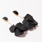 Par de aros colgantes negros con forma de pétalos y base dorada.