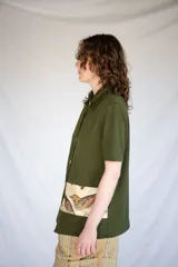 Camisa verde militar de manga corta con botones nacarados y corte estampado en el delantero con diseño de aves.