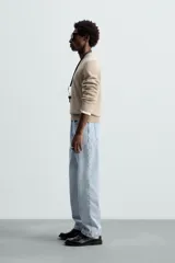 Jersey de punto color beige, con cuello en V y mangas largas.