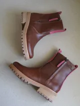 Botas cortas de cuero color marrón con cierre de cremallera lateral y detalle de ribete rosa.