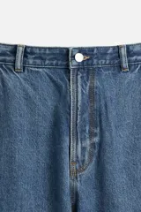 Pantalón de jean negro, corte relaxed fit, con bolsillos frontales y traseros tipo parche, tira multifunción y bolsillo tipo parche en las piernas. Tiene efecto lavado y cierre frontal con cremallera y botón.