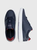 Zapatillas urbanas Tommy Hilfiger color azul marino, con cordones, suela blanca y detalles en rojo. Logo de la marca en el lateral y la lengüeta.
