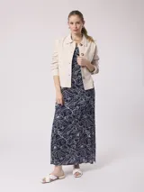 Chaqueta color beige de corte recto, con cuello camisero, cierre frontal con botones, dos bolsillos de parche en el pecho y mangas largas con puños abotonados. Confeccionada en mezcla de lino y algodón.