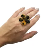 Anillo dorado con aplique de flor de resina tipo carey, de tamaño regulable.