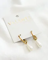 Aros colgantes con argolla dorada y dije de perla sintética en forma de lágrima.