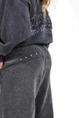 Pantalón de jogging unisex color negro lavado, confeccionado en frisa gamuzada, con cordón de ajuste en la cintura y bordado en la espalda.