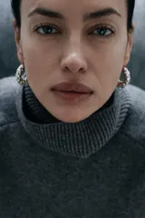 Sweater gris de lana con cuello alto, corte oversize y mangas largas acampanadas.
