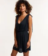 Vestido corto de playa color negro, confeccionado en crepé, con escote delantero y trasero, fruncido con lazo en los hombros y sin estampa.