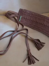 Faja ancha de cuero color marrón con detalles trenzados y lazo lateral con flecos en el extremo.