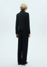 Pantalón negro de corte recto y tiro alto, con pliegues frontales y diseño minimalista.
