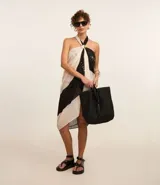 Pareo rectangular de gasa chiffon con estampado geométrico en blanco y negro, y borlas bicolores en las puntas.