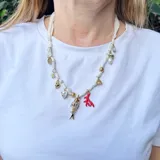 Collar corto hecho en pañuelo marrón con mix de dijes dorados, rojos y blancos.