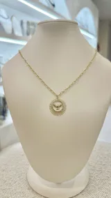 Collar dorado con cadena de eslabones y dije circular con la figura del Espíritu Santo en el centro.