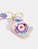 Llavero con forma de cámara de fotos rosada con detalles en lila y celeste. Incluye un dije con forma de conejo con auriculares y un strap con la palabra "music".