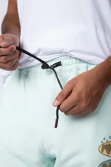 Pantalón de jogging negro de corte oversize, con puños elásticos y estampado con la palabra 'FUTURO' en verde y amarillo.