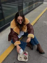 Campera de cuero color marrón con cuello y puños de piel sintética color beige.