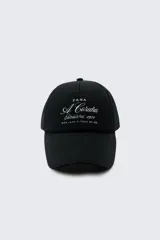 Gorra de béisbol negra de Zara con bordado frontal en blanco que dice "A Coruña Established 1975 Rúa Juan Flórez 64-66".