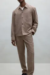 Pantalón de vestir color beige con textura de lino, corte recto, bolsillos laterales y traseros con botón. Cierre con cremallera y botón oculto.