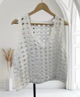 Chaleco blanco de tejido de punto abierto con textura, corte holgado y escote amplio.