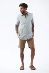 Camisa blanca de manga corta con cuello clásico y cierre frontal con botones.