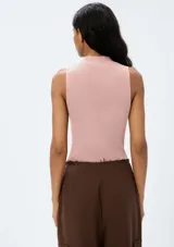 Musculosa rosa de tejido acanalado con cuello alto.