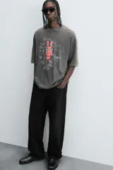 Camiseta gris con efecto lavado, cuello redondo y manga corta. Estampado frontal con conejo, texto y efecto de pintura.