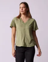 Remera verde con tejido melange, escote en V y aplique de crochet en la parte delantera.