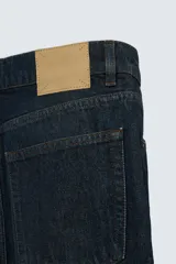 Jeans azul oscuro de corte recto, con largo al tobillo, confeccionados en denim de algodón con efecto lavado. Diseño de cinco bolsillos y cierre frontal con botones.