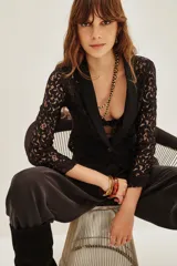 Saco corto de encaje negro con solapas de satén y un botón frontal.