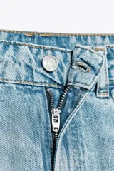 Bermuda de jean celeste de tiro medio con cinco bolsillos, efecto lavado y bajo sin costura.